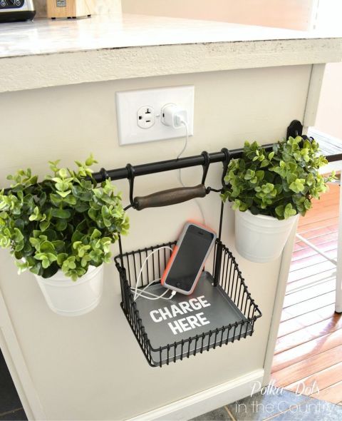Normally the side of your cabinets end up bare and without a purpose. But here, a rail is hung near an awkwardly-placed outlet with a basket for phones and specific directions to "charge here." Genius, if you ask us. See more at Hometalk » 