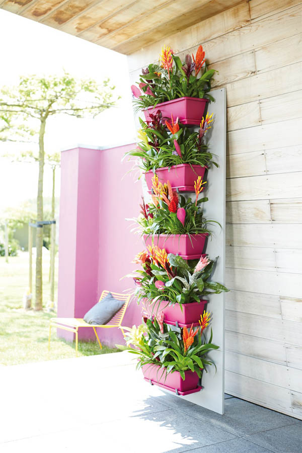 03-bright-pink-adds-a-pop-of-color-and-accents-vibrant-bromeliads-vertical-garden-homebnc